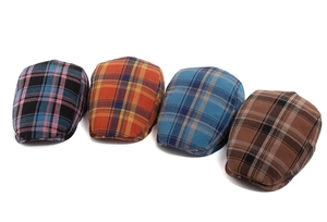 Detail shot of four plaid flat caps in various colors with retro British style patterns
