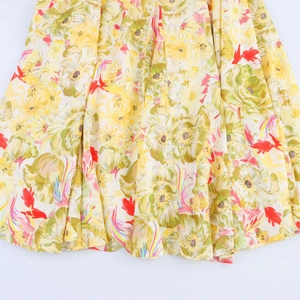 Detail of yellow floral print linen-blend dress with retro pleated fabric texture