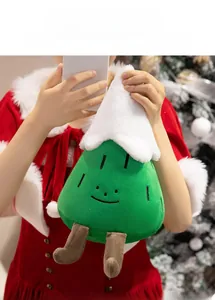 Close-up of cute plush Christmas tree doll held by a model in a festive holiday scene