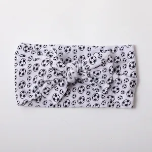 Detail of soft nylon baby headband with classic black and white soccer print and bow knot