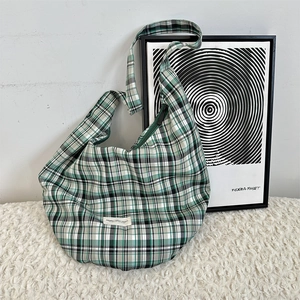 Détail du sac hobo en toile à carreaux verts avec fermeture éclair et bandoulière