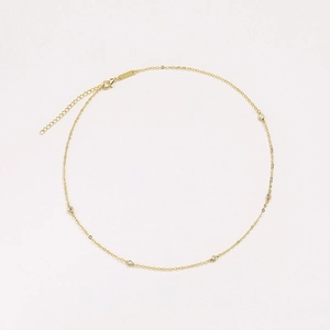 Detail of thin gold choker chain featuring five inset zircons and adjustable lobster clasp