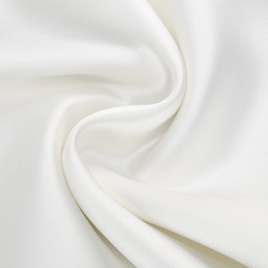 Close-up of white satin fabric with smooth glossy texture and elegant spiral drapes