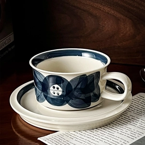 Close-up of vintage ceramic coffee cup with blue floral hand-painted pattern detail