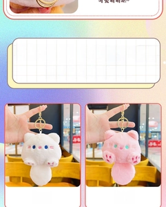 Dettaglio di portachiavi a forma di gatto in peluche rosa e bianco con moschettoni dorati