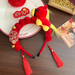 Detail of red plush zodiac horse headband with golden tassels and festive embroidery