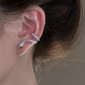 Boucles d'oreilles serpent avec zircons blancs et pierre verte portées par mannequin