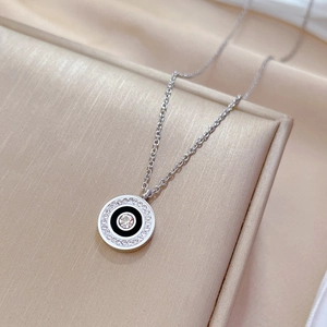 Macro shot of silver titanium steel necklace with black enamel pendant and small crystals