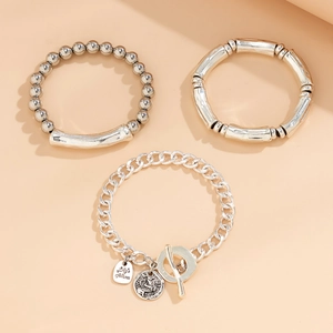 Detailed view of layered silver beaded bracelets with T-bar clasp and heart pendants