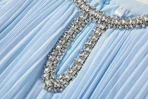 Détail du col plissé bleu ciel avec broderies de perles et strass sur la robe évasée