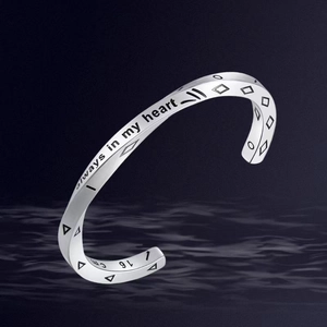 Detailed macro view of twisted silver bangle with engraved always in my heart slogan