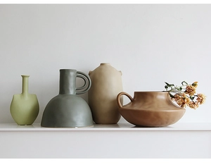 Detail view of four minimalist matte ceramic vases in artistic Morandi colors and shapes