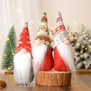 Drie kerstkabouters met gebreide mutsen en nepbont baarden op houten ondergrond