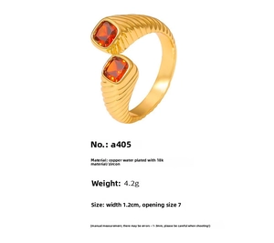 Macro shot of gold plated copper ring featuring red zircon stones and striped texture