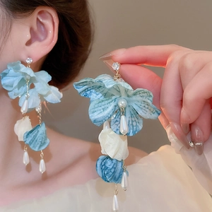 Detailed view of floral tassel earrings with blue fabric petals and teardrop pearls