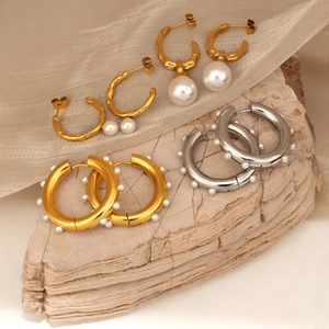 18K gold and silver hoop earrings with white pearls on elegant silk background