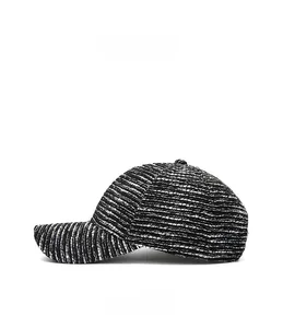 Close-up of black and white textured tweed baseball cap with a curved brim profile