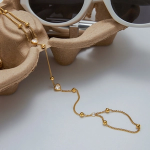Detail view of a refined 18K gold-plated stainless steel chain with heart-shaped pendants