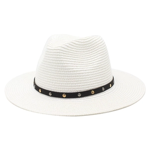 Close-up of white woven Panama hat with black decorative band and metallic studs