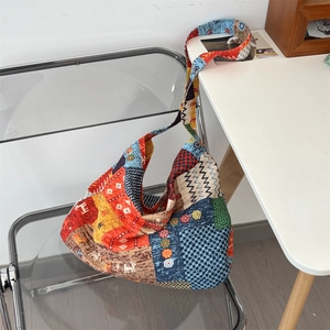 Détail du sac bohème en toile patchwork avec motifs géométriques sur une chaise