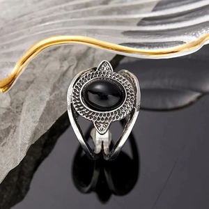 Macro shot of vintage silver ring with oval black stone and intricate woven texture