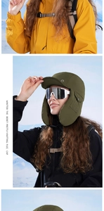 Detail of olive green winter trapper hat with ear flaps and ski goggles for outdoor sports