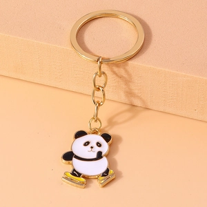Detail of cute enamel skating panda keychain with golden metal ring for backpacks