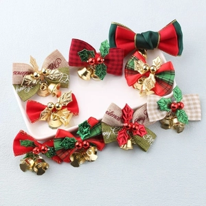 Close-up of assorted plaid Christmas bows with golden bells and green leaf accents