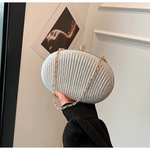 Detail of silver clutch bag featuring vertical pleats and a diamond-encrusted spherical clasp
