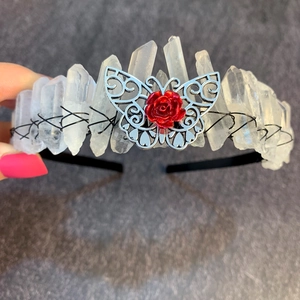 Detail of crystal crown with silver butterflies, red roses and black wire wrapping