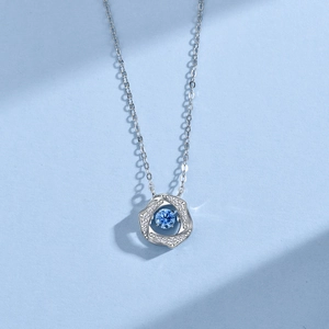 Macro shot of silver S925 necklace with blue central zircon and white accents