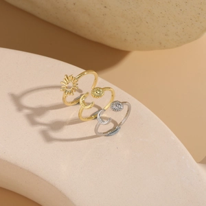 Macro detail of sun and moon open rings in gold and silver finish on a stone prop