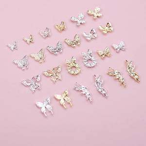 Detailed view of mixed gold and silver 3D butterfly nail charms with rhinestones
