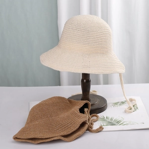 Detail of woven straw sun hats in beige and khaki colors with a fine textured finish