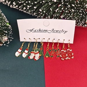 Christmas enamel earring set featuring snowman and tree designs on a white gift card