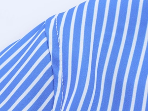 Macro shot of vertical light blue and white stripes with neat stitching on a loose shirt