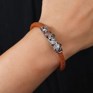 Men's vintage brown braided leather bracelet featuring a detailed silver dragon charm
