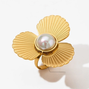Detail eines verstellbaren goldenen Perlenrings mit Muschelform und Metallstruktur