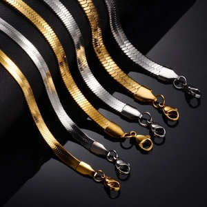 Polished gold and silver flat snake chain necklaces with lobster clasps on black background