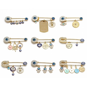 Golden Hamsa hand and Evil Eye safety pin brooches set with crystal rhinestones
