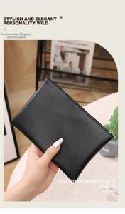 Close-up of black lychee grain PU leather pouch held by hand in a cozy interior setting