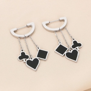 Detailed macro of silver steel tassel earrings featuring black poker suit pendants