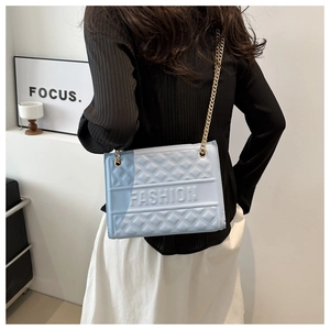 Close-up of embossed light blue PU leather crossbody bag with golden chain strap