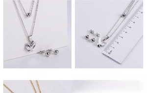 Detail of silver titanium jewelry set featuring a butterfly pendant and ball studs with scale