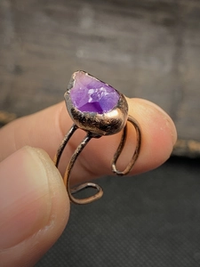 Macro detail of antique bronze adjustable ring featuring a natural raw amethyst stone