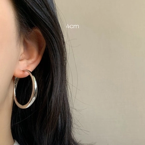 Close-up of model wearing 4cm chunky silver hoop earrings in a minimalist retro style