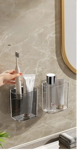 Detail view of transparent and smoke gray wall-mounted bathroom organizer storage boxes