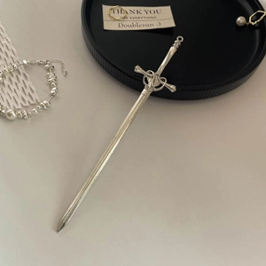 Close-up of silver metal sword hair stick with retro hollowed-out pattern detail