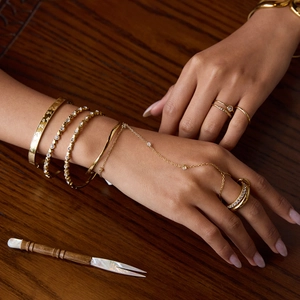 18K gold plated stainless steel bracelets and rings with zircon hearts on wood surface