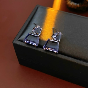 Macro shot of geometric purple zircon earrings with triangular and trapezoid crystals